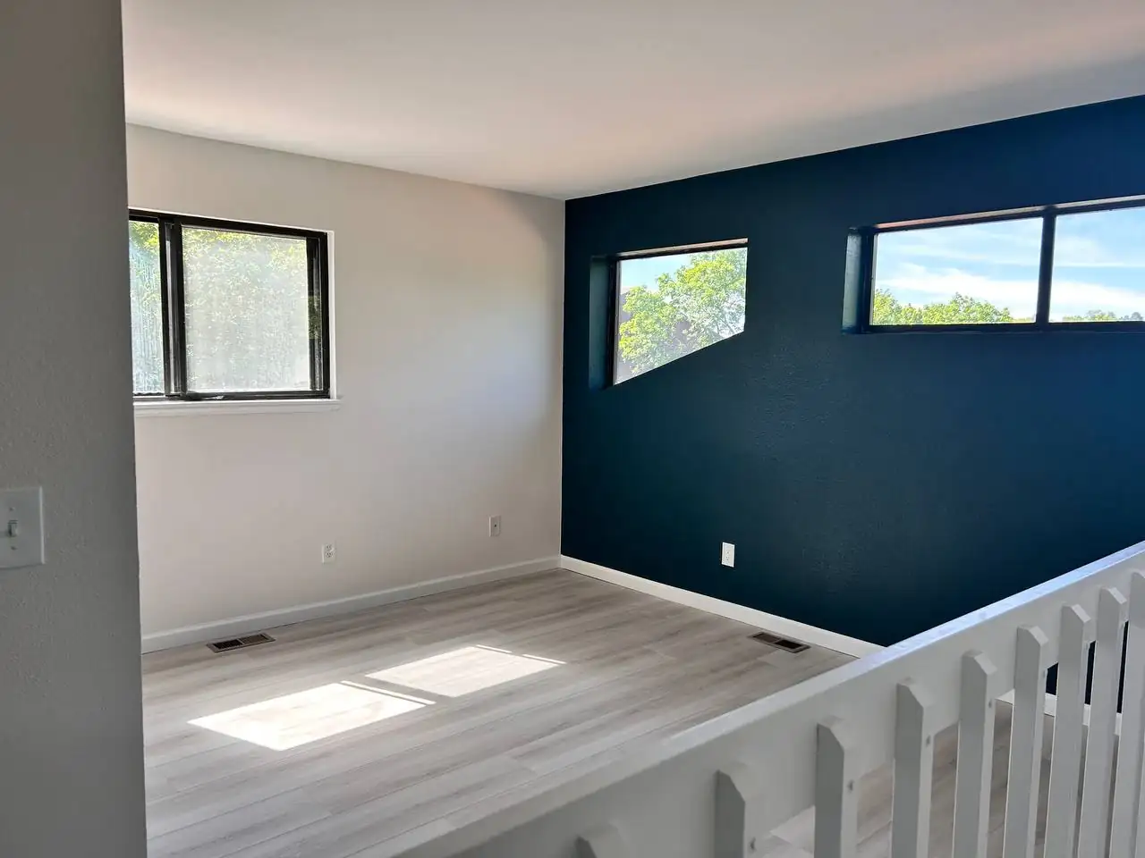 Interior room painting with modern dark accent wall and light flooring in Denver