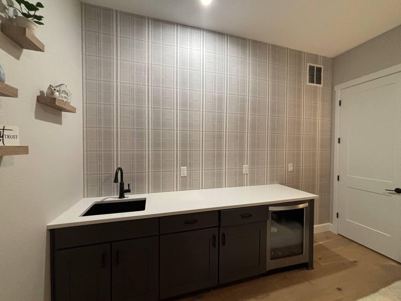 Laundry room with plaid wallpaper and custom cabinetry