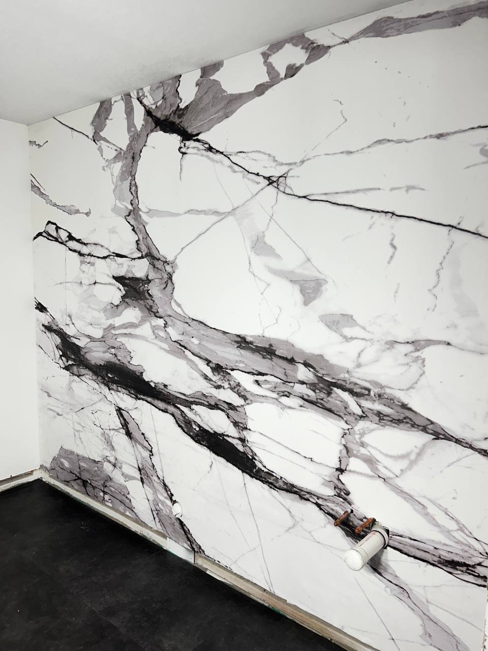 Professional wallpaper hanging project with precise cuts around trim and wall edges